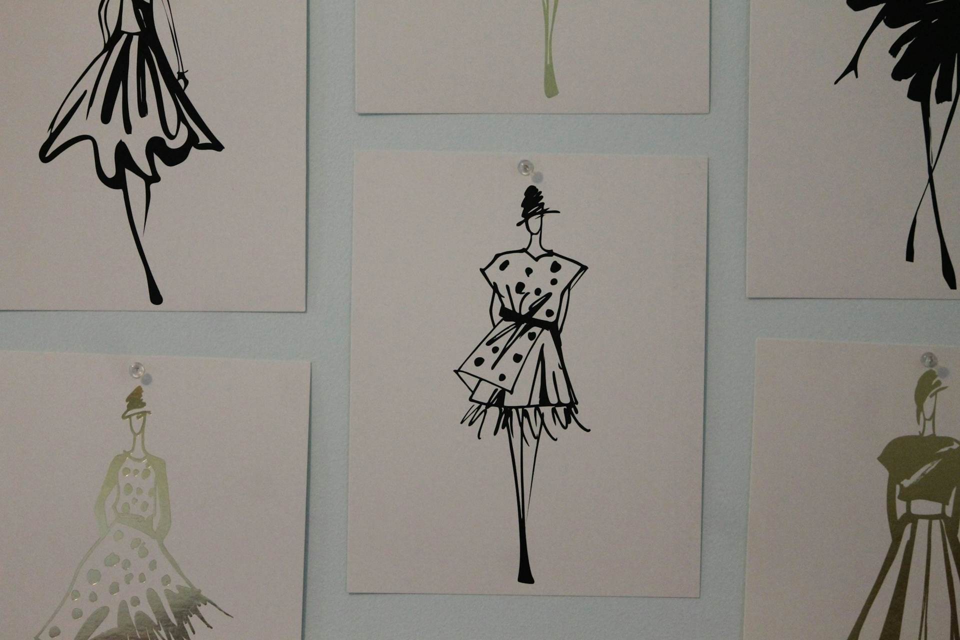 Fashion sketches pinned to a studio wall