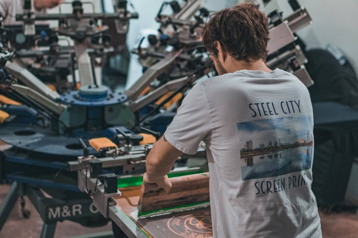 Screen printer loading a t-shirt on a carousel press
