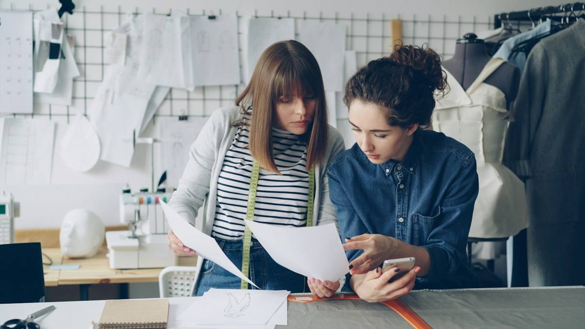 Two designers reviewing garment sketches