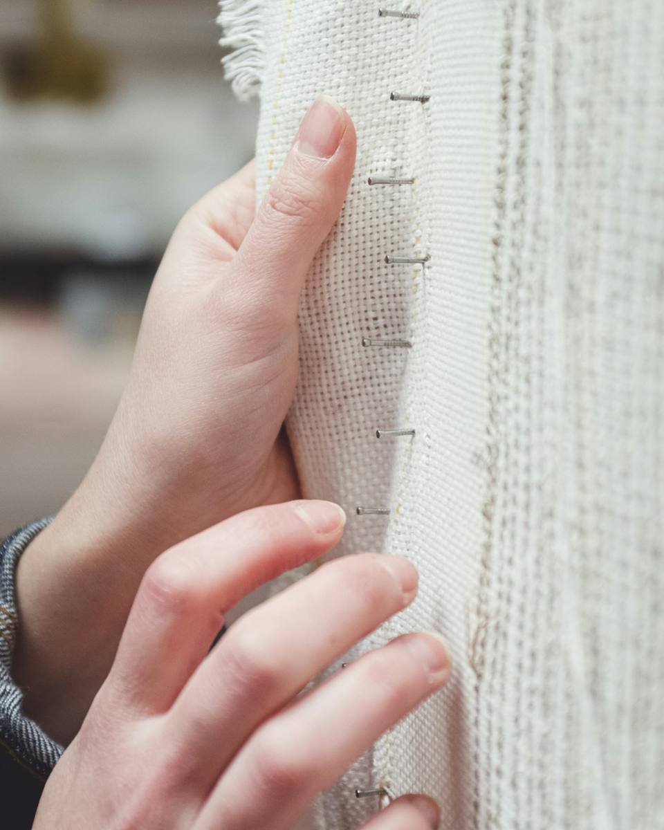Hand checking a seam on white fabric