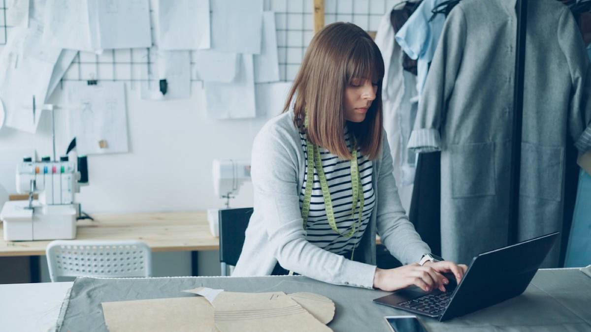 Person working on a laptop in a clothing studio